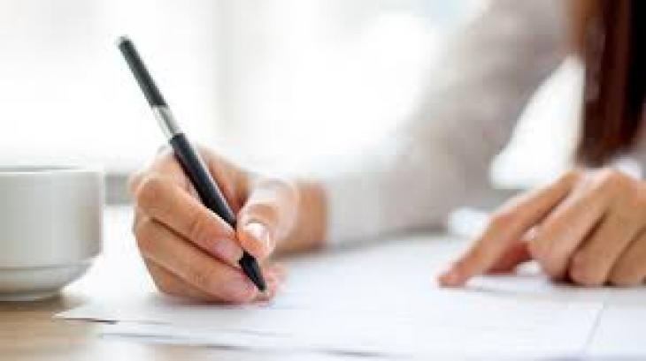 matury poprawkowe - ręka z długopisem wypełniająca formularz